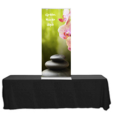 Blade Lite 24 tabletop retractable banner stand on a table with graphic banner.