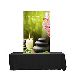 Tabletop banner stand with retractable graphics on a 6' table with black unprinted table cover